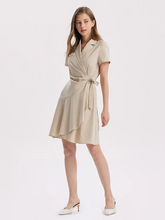 a lady in a beige v-neck notched lapel wrapped mini dress